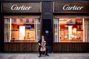 man playing violin in front of store
